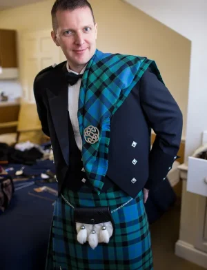 Ein Mann trägt MacDowall Tartan Kilt und eine Kiltjacke.